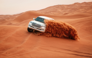 a car on sand dunes in dubai
